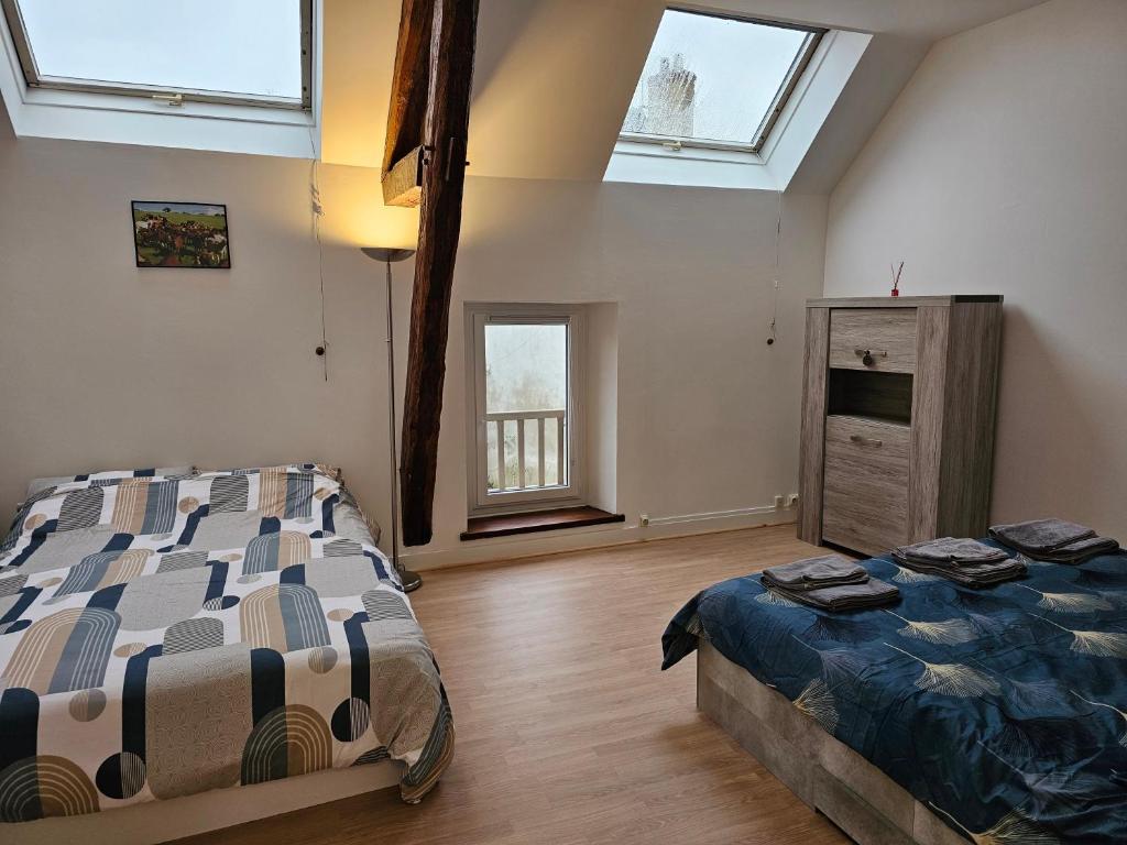 a bedroom with a bed and a dresser and windows at Gîte entre vigne et loire Sancerre in Sancerre