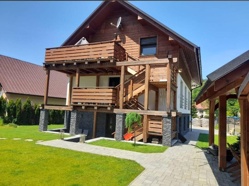 a large wooden house with a large deck at Apartmánový Dom Terchová in Terchová