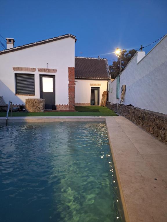 a swimming pool in front of a house at El Antiguo Corral de Sevilla in Navalcán