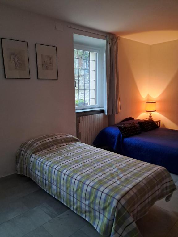 a bedroom with two beds and a window at Pedro Country House in Canossa