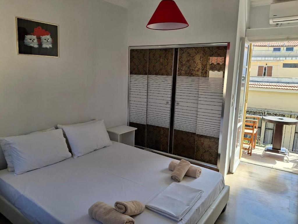 um quarto com uma cama branca com toalhas em Nafpaktos happy town studio in port em Lepanto