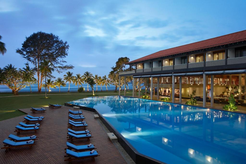 un hotel con piscina y tumbonas en Cinnamon Bey Beruwala, en Bentota
