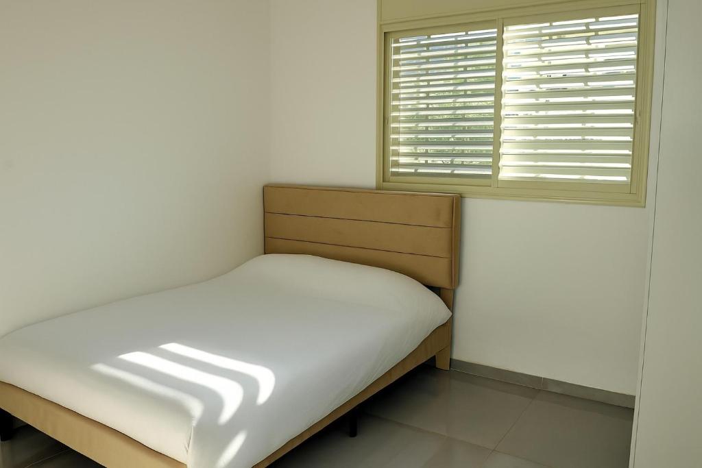 een kleine slaapkamer met een bed en een raam bij לב בית שאן in Bet Sheʼan