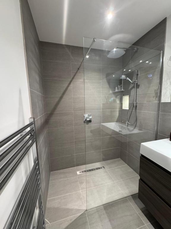 eine Dusche mit Glastür im Badezimmer in der Unterkunft Turnpike House in Glanton