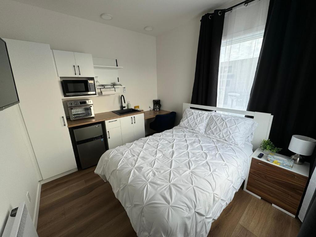 AmosLoft Le Sommet的一间带床和厨房的小卧室