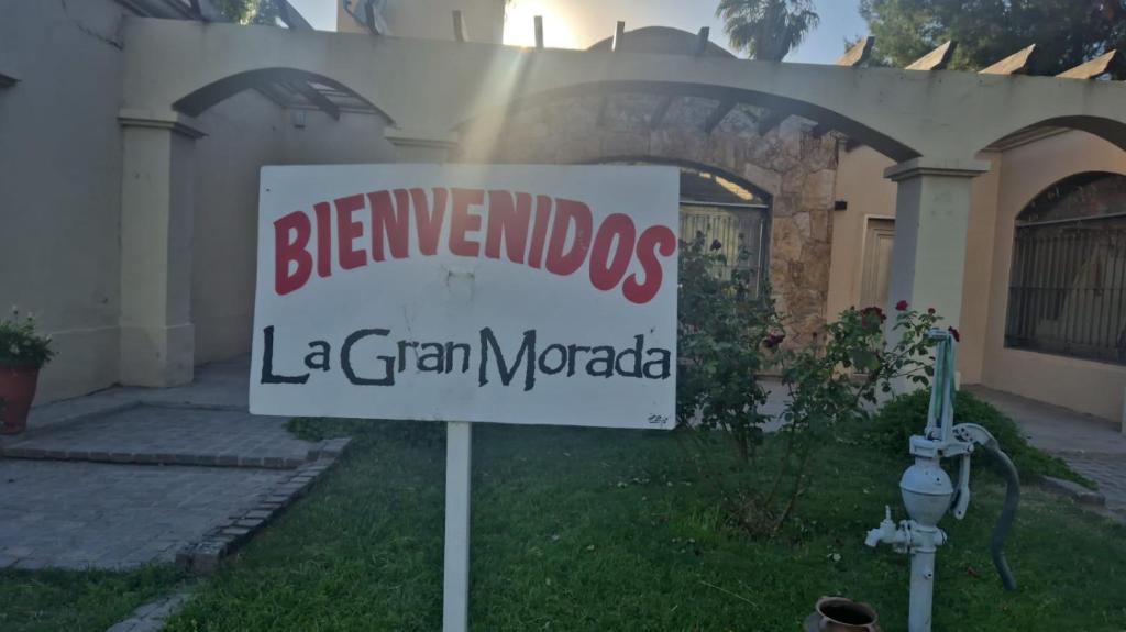 a sign in the grass in front of a house at La gran morada in Corralitos