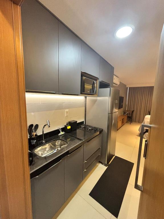 a kitchen with a sink and a stainless steel refrigerator at Azzure Apartmento 103 Intermares in Cabedelo