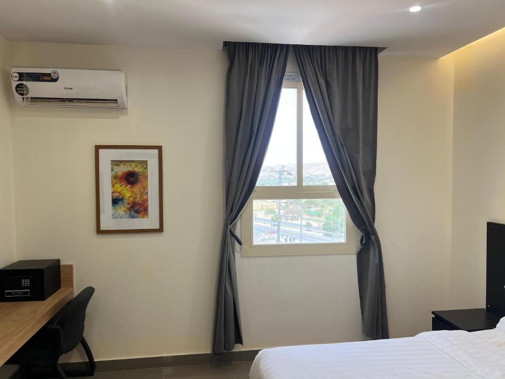 a bedroom with a bed and a window at شقق نازلين للشقق المخدومة in Al Bahadah