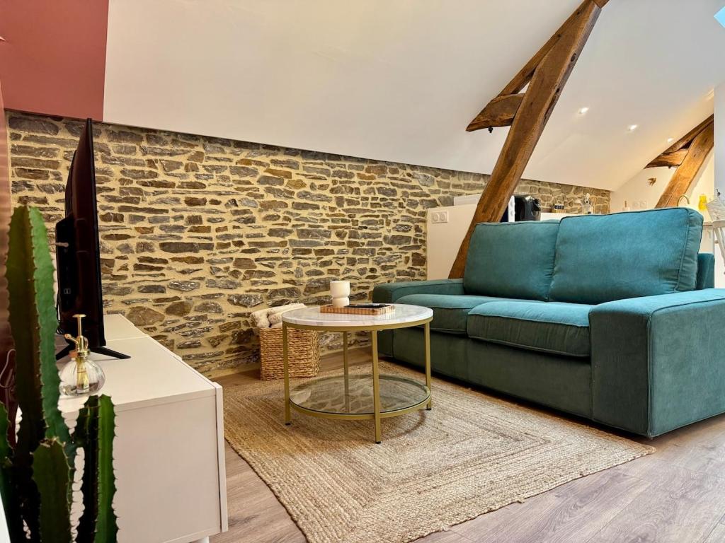 un salon avec un canapé bleu et une table dans l'établissement Le Grenier d'Antan - Near Mont-Saint-Michel, à Pontorson