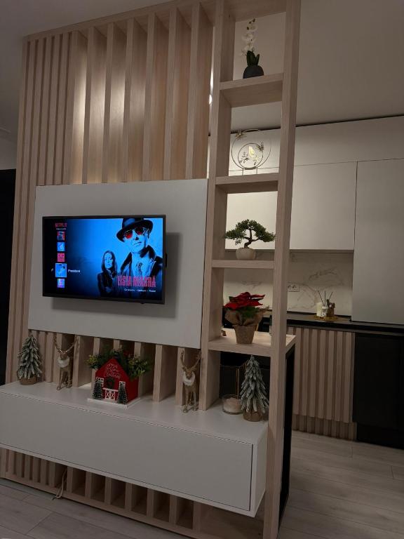 een woonkamer met een flatscreen-tv aan de muur bij President 59 in Craiova