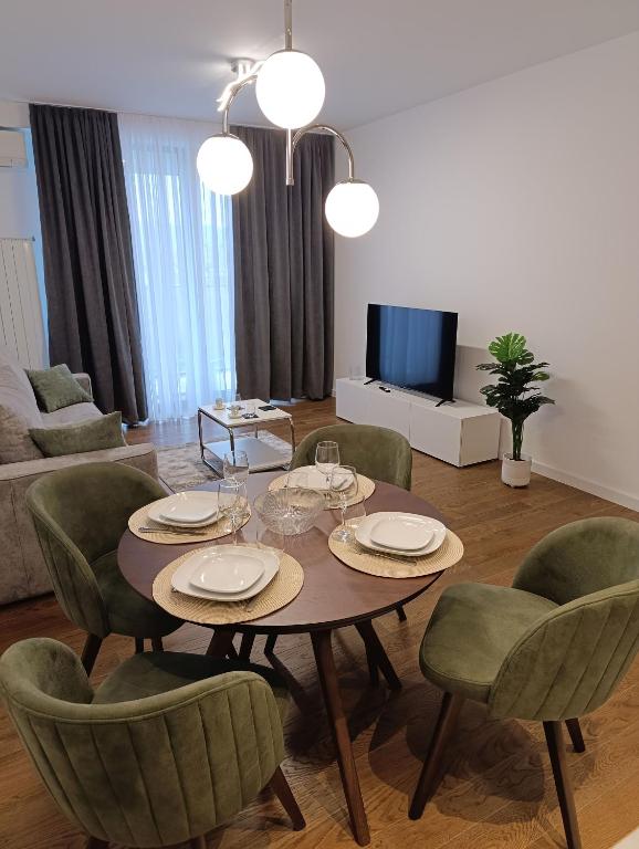 a living room with a dining table and chairs at Planet Green Residence in Niš