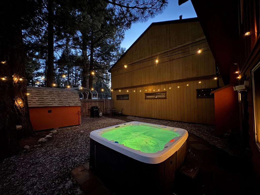 eine Whirlpool-Badewanne auf einem Hof neben einem Gebäude in der Unterkunft Modern Big Bear Cabin With Spa, BBQ & EV Charging on Site in Big Bear City Airport