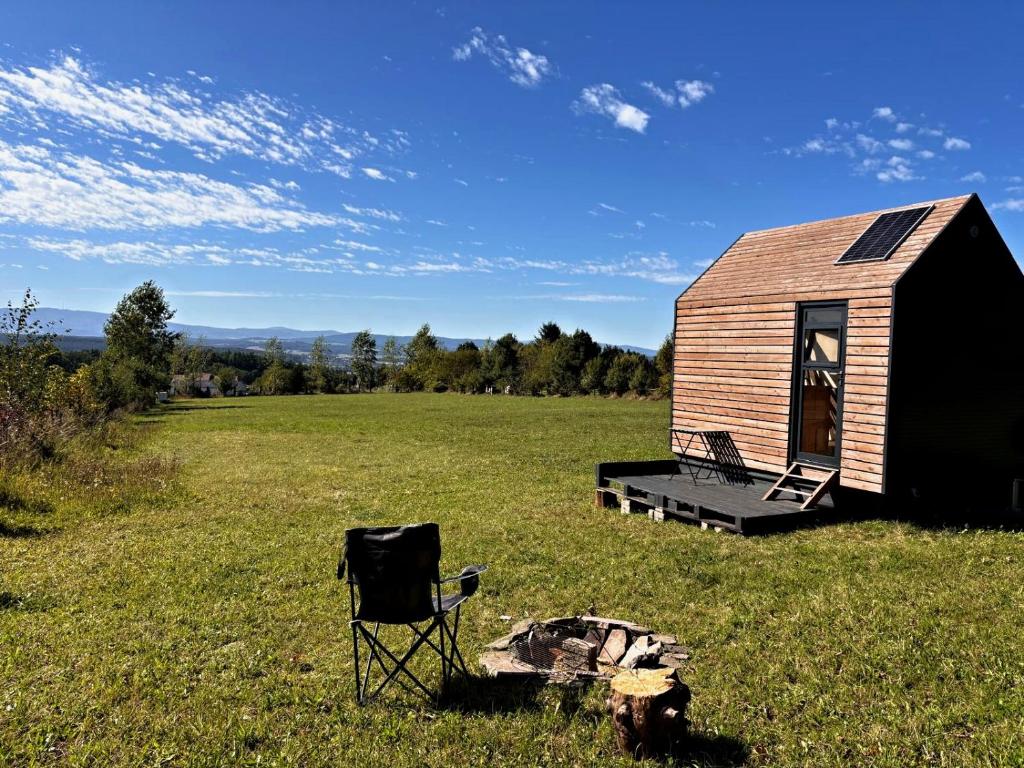 a chair and a tiny house in a field at Políčko in České Budějovice