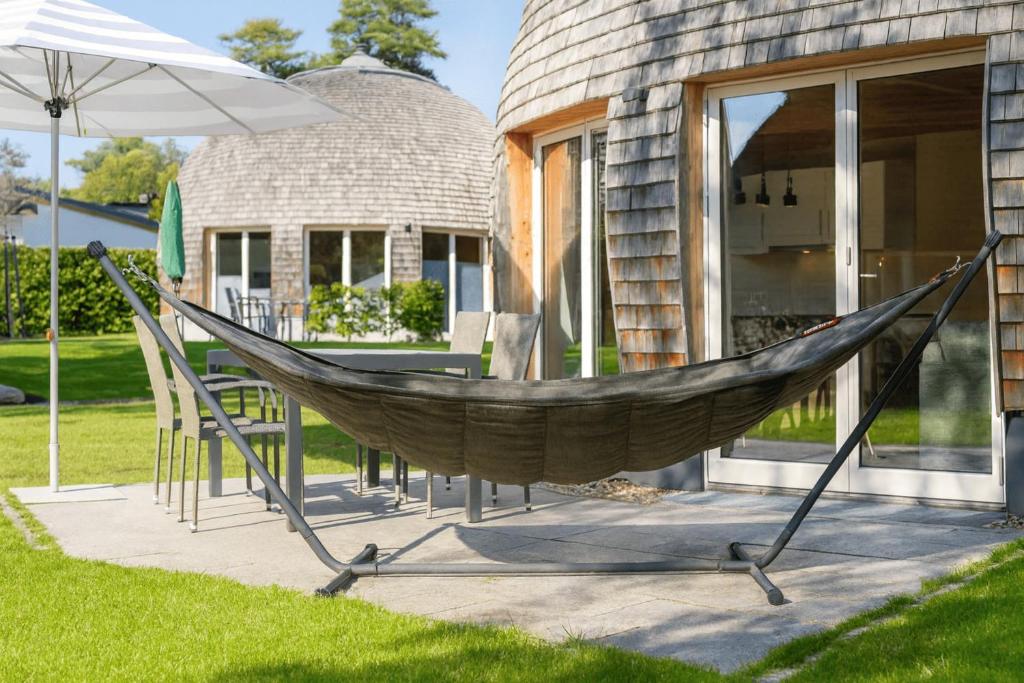 a hammock in front of a house at Nordkugel - Rundes Wohnglück am Tollensesee in Penzlin