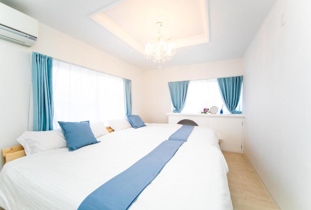 a bedroom with a large white bed with blue accents at Awaji Centaral Villa in Shizuki - Vacation STAY 81902v in Shizuki