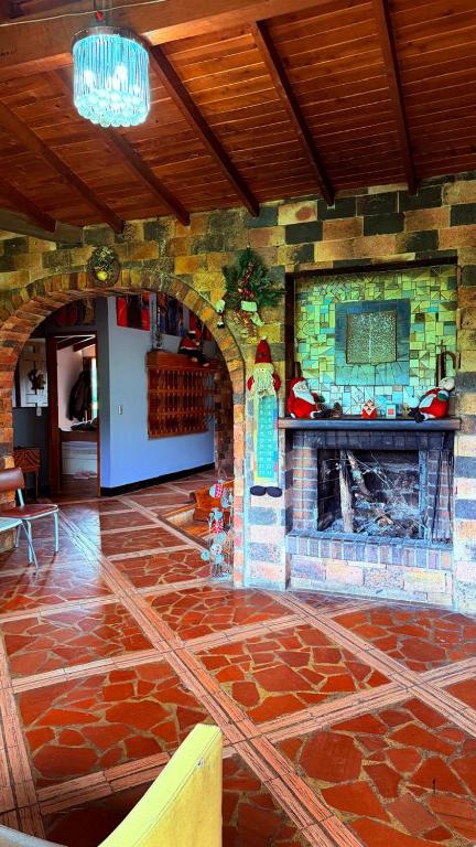 a stone fireplace in a room with a stone floor at Finca 5 Continentes - Cerca MatroCable ARVI in Guarne
