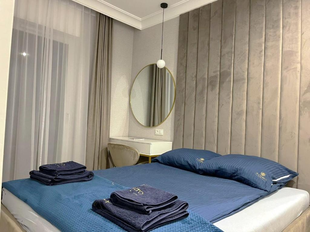 une chambre avec un lit avec des draps bleus et un miroir dans l'établissement Let's Sea SPA - Premium Apartamenty z ogródkiem, przyjazne zwierzętom, à Gąski