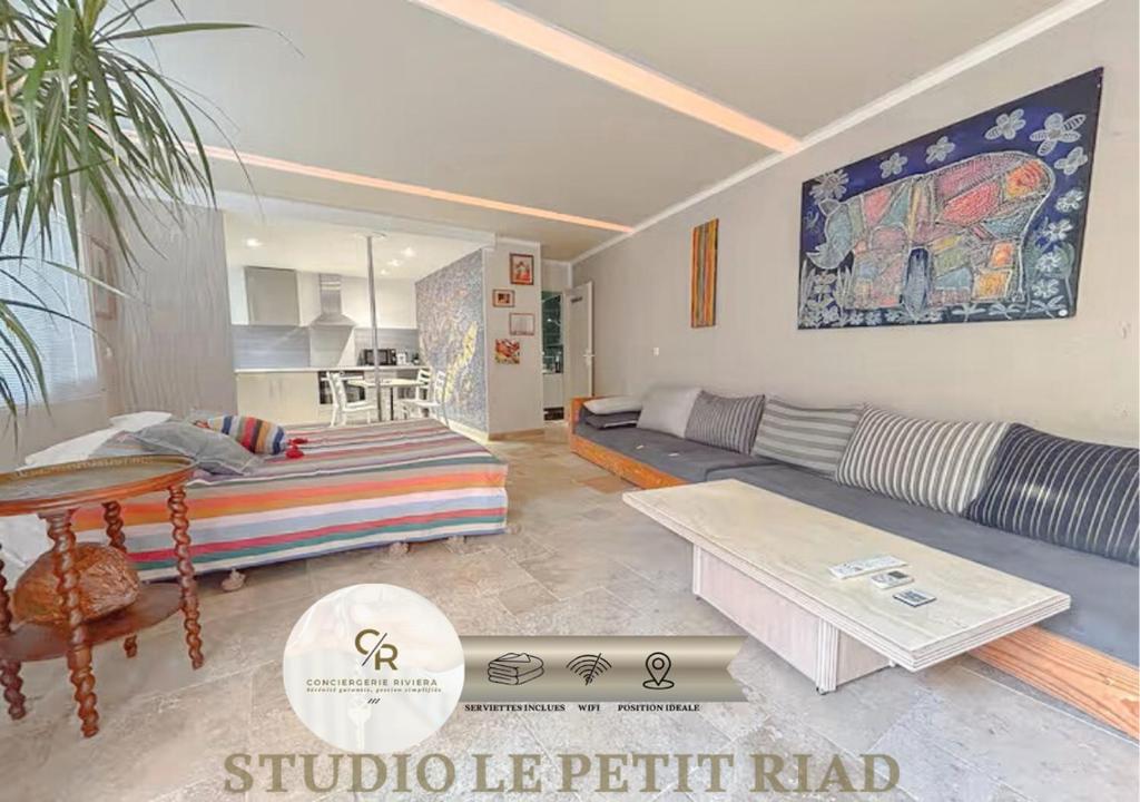 a living room with a couch and a table at Studio le Petit RIAD,climatisée,proche plage in Fréjus