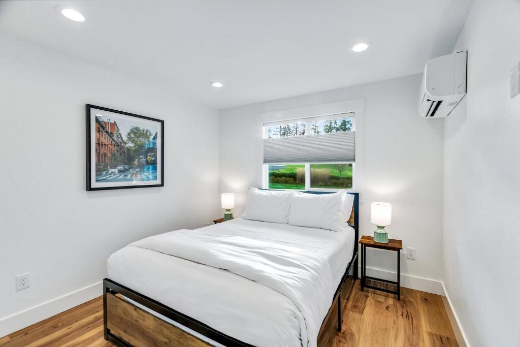 ein weißes Schlafzimmer mit einem Bett und zwei Lampen in der Unterkunft Sunny 3BR Retreat Near Everett Waterfront in Everett