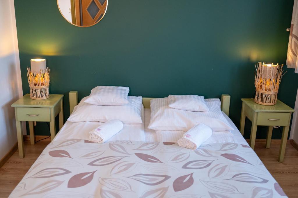 a bedroom with two beds and two nightstands with two lamps at Oberża in Czeladź