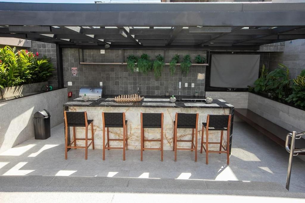 une cuisine extérieure avec quatre chaises autour d'une table dans l'établissement Aptos 1501, 2101 e 2801, à Rio de Janeiro