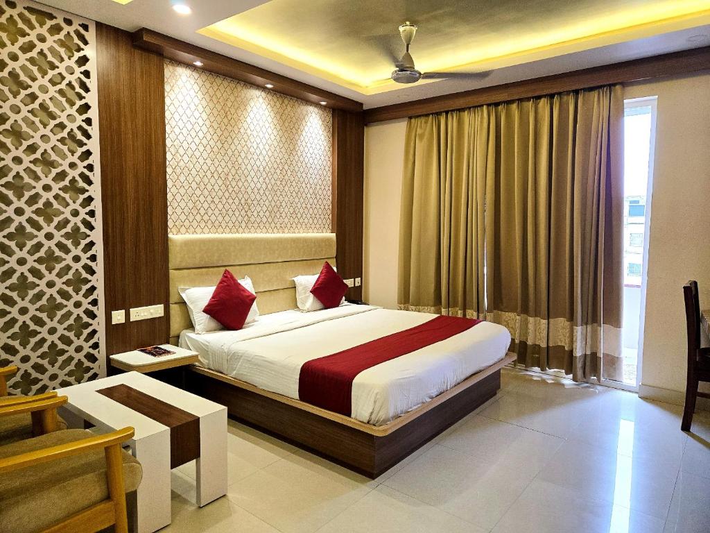 a bedroom with a bed and a window at Kuber - Palace Premium # Restaurant- Lift and Free Parking Facilities - Fully Air Conditioning Premium Room in Puri