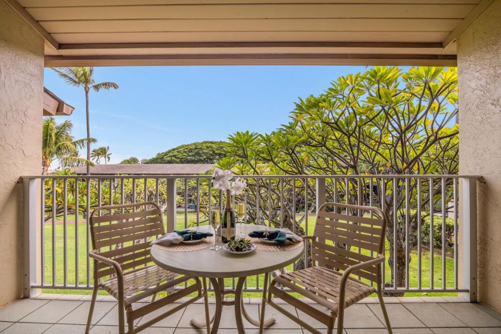 卡普鲁亚Napili Shores F248的阳台上的桌子和椅子，可以欣赏美景