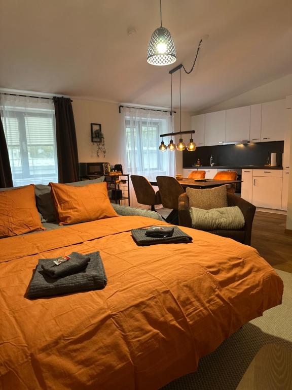 um quarto com uma grande cama laranja e uma sala de estar em Topspot Wallis 30 min nach Zermatt oder SaasFee em Stalden