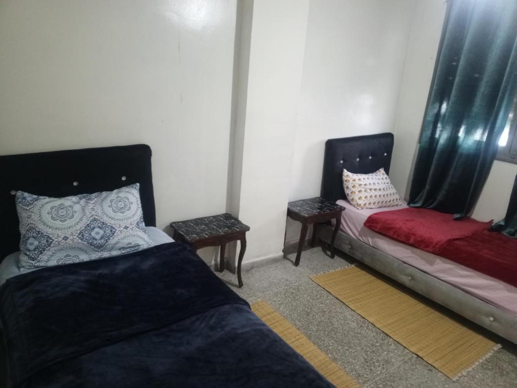 非斯KASBAH Guests Travel的一间设有两张床和两张桌子的房间