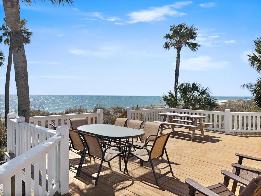 een houten terras met stoelen en een tafel op een balkon bij Beach Blessing in Edisto Island