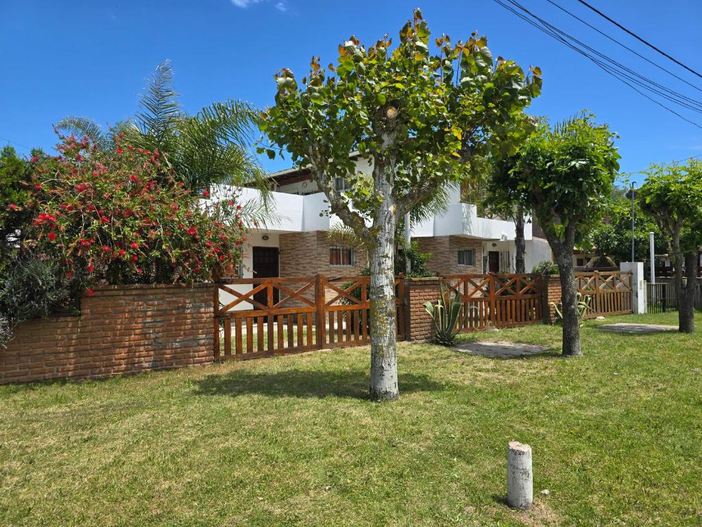 a house with two trees in a yard at Alojamientos frente al Mar Complejo "El Estar De La Costa" in San Clemente del Tuyú