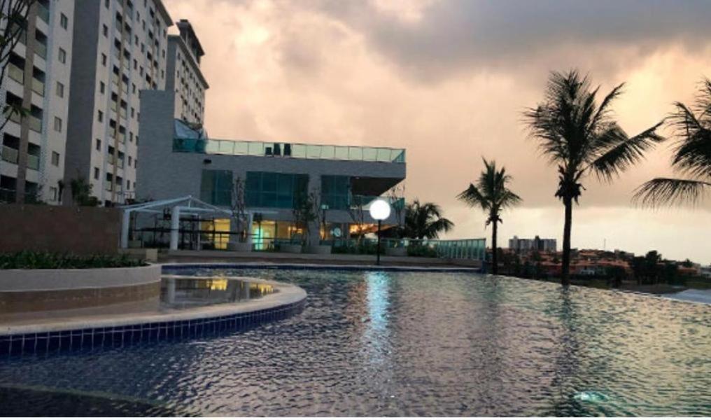 ein Swimmingpool vor einem Gebäude mit Palmen in der Unterkunft Salinas Park Resort in Salinópolis
