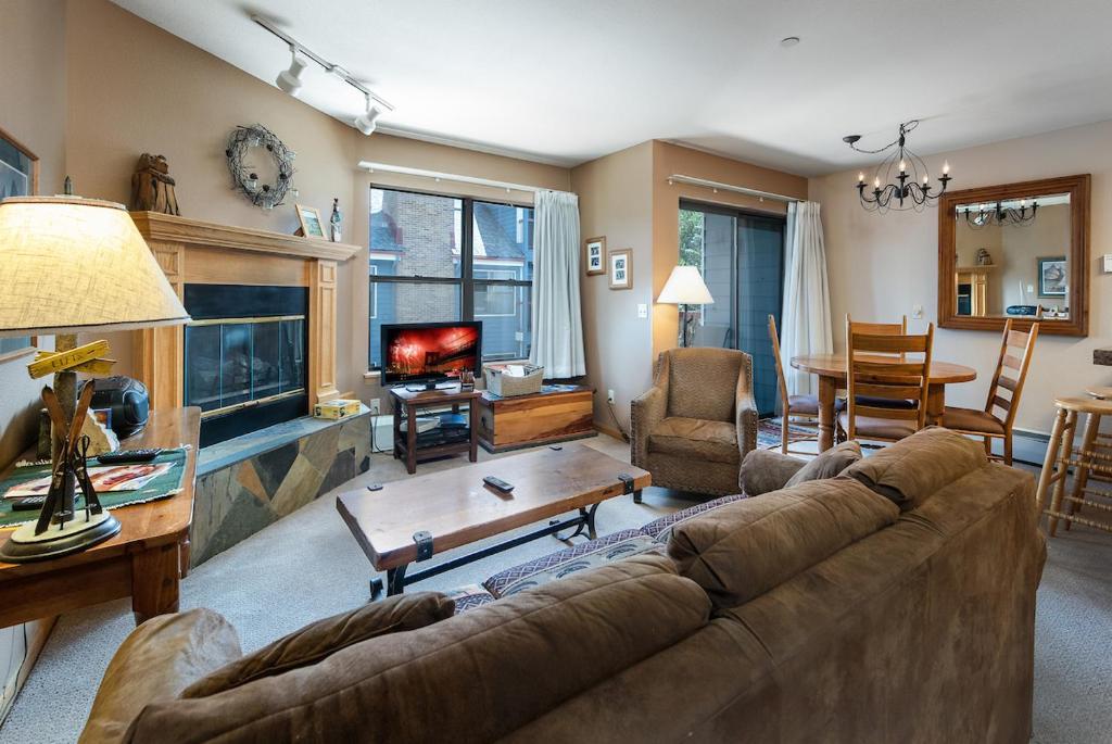 a living room with a couch and a fish tank at River Mountain Lodge Peaks Trail Condo: Ski-In, Downtown Breck in Breckenridge