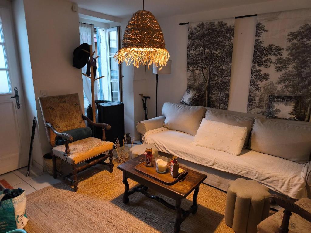 ein Wohnzimmer mit Sofa und Tisch in der Unterkunft The Cottage at 7 in Sainte-Foy-la-Grande