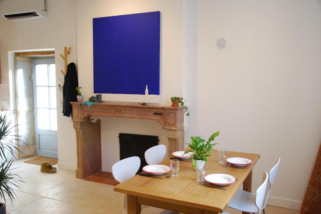 een eetkamer met een tafel en een open haard bij Jolie maison ancienne in Fleurey-sur-Ouche