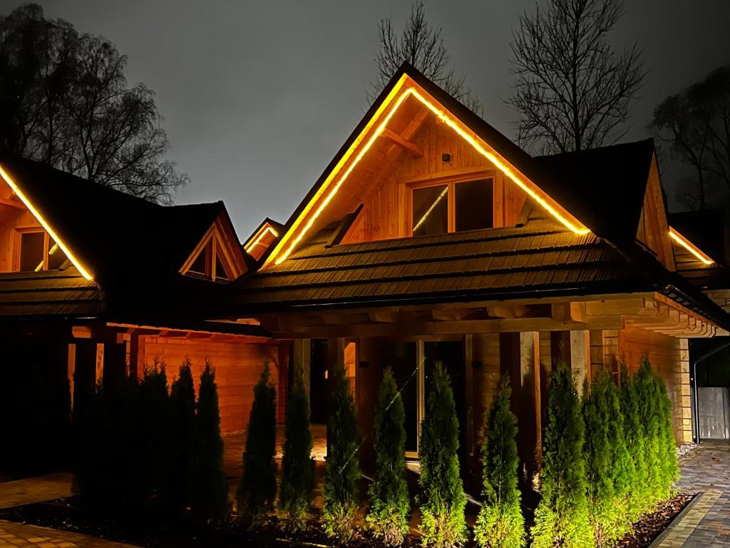 a house with lights on the roof at night at Domki Michelle in Wisła
