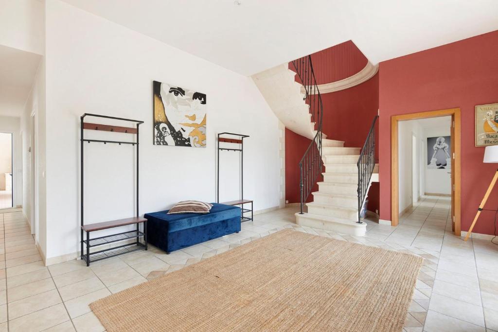 a living room with a staircase and red and white walls at La Tour Maréchal - Gîte d'exception avec piscine in LʼHerbergement