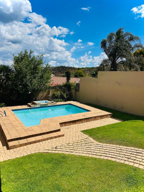 a swimming pool in a yard with a brick patio at Suider home stay in Johannesburg