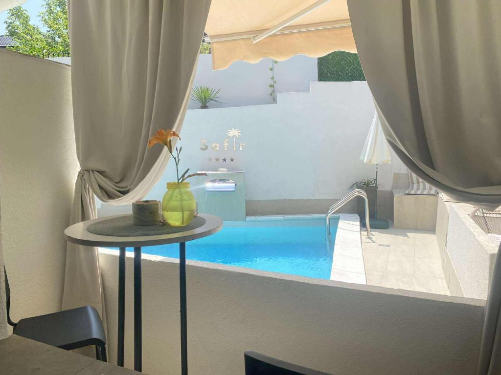 - une table avec un vase à côté d'une piscine dans l'établissement Apartman Safir 1 & Apartman Safir 2 & Apartman Safir 3, à Kruševac