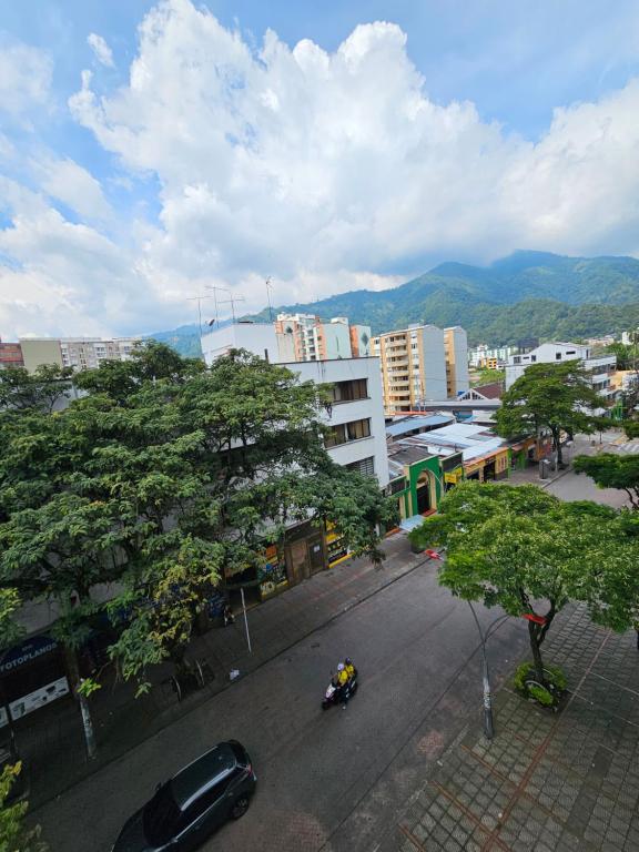 una calle de la ciudad con un coche aparcado en una ciudad en Apartaestudios centro ibague, en Ibagué