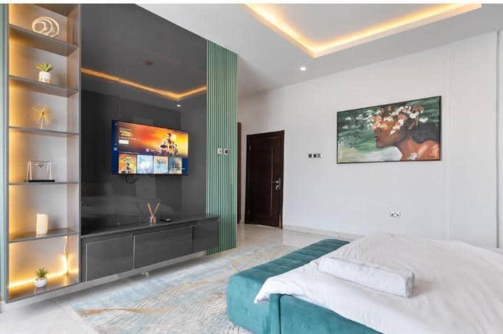 a bedroom with a bed and a flat screen tv at 3 bedroom Masionette in Lekki