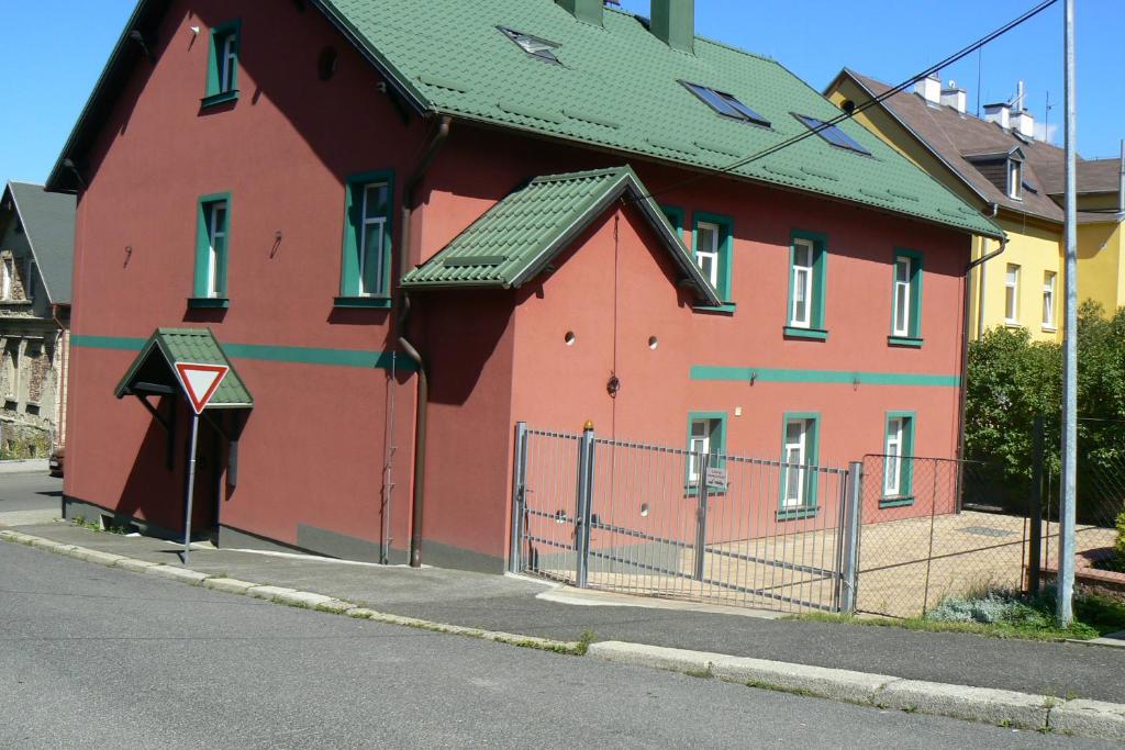 een groot rood gebouw met een groen dak bij Penzion Na Vápence in Liberec