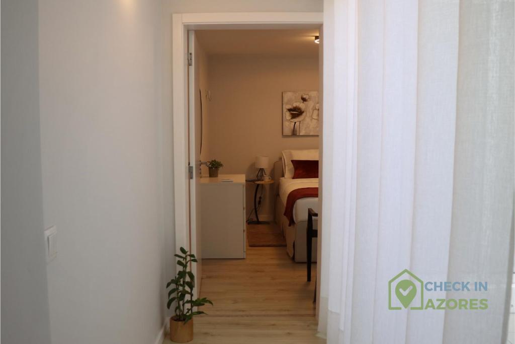 een hal die leidt naar een slaapkamer met een bed bij Cantinho da Bea I in Angra do Heroísmo