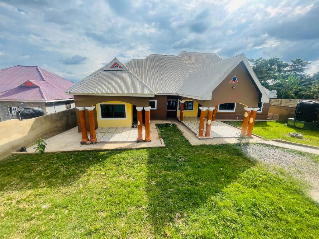 a small house with yellow and orange posts in the yard at AnKeS Lodge in Kontrajeso