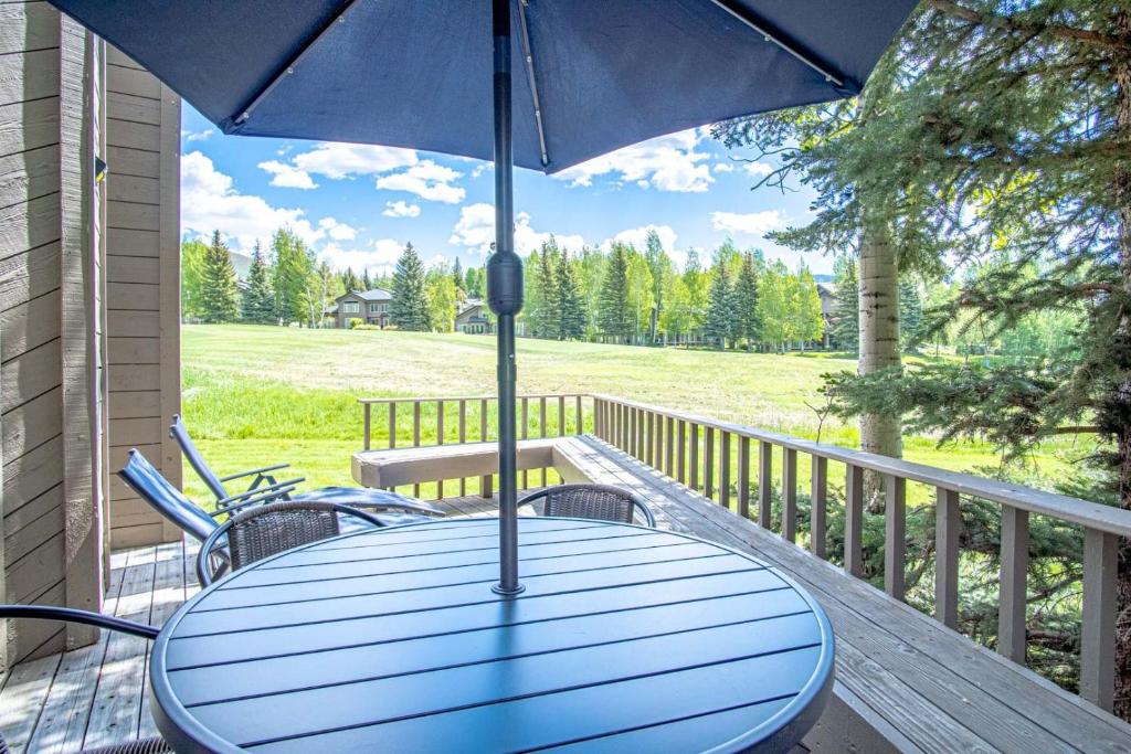 a blue table with an umbrella on a porch at Modern Golf View Condo + Resort Amenities in Sun Valley