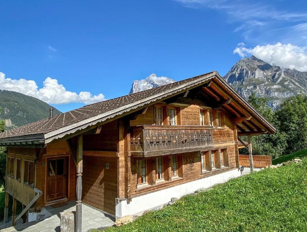 eine Blockhütte mit Balkon in den Bergen in der Unterkunft Ferienhaus Chalet Simeli in Grindelwald