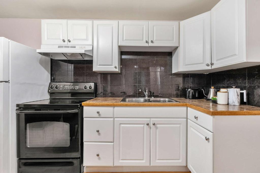 eine weiße Küche mit weißen Schränken und einer Spüle in der Unterkunft The Arizona 2BR Pet-Friendly Suite Calgary SE in Calgary