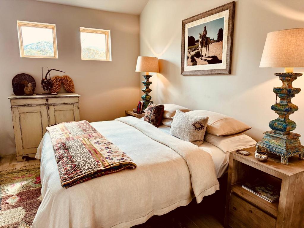 ein Schlafzimmer mit einem Bett und einem Tisch mit einer Lampe in der Unterkunft Santa Fe Modern FARMHOUSE 1 ACRE PRIVATE RD SOAKING ROOM 3 min Canyon rd in Santa Fe
