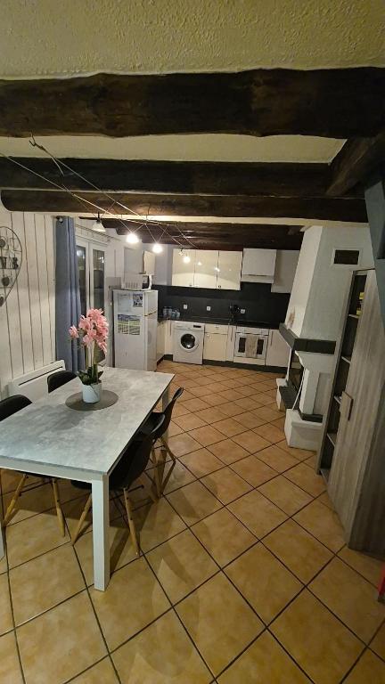 a kitchen with a table and chairs in a room at Charmante maison près des bords de la Loire in Beaufort-en-Vallée