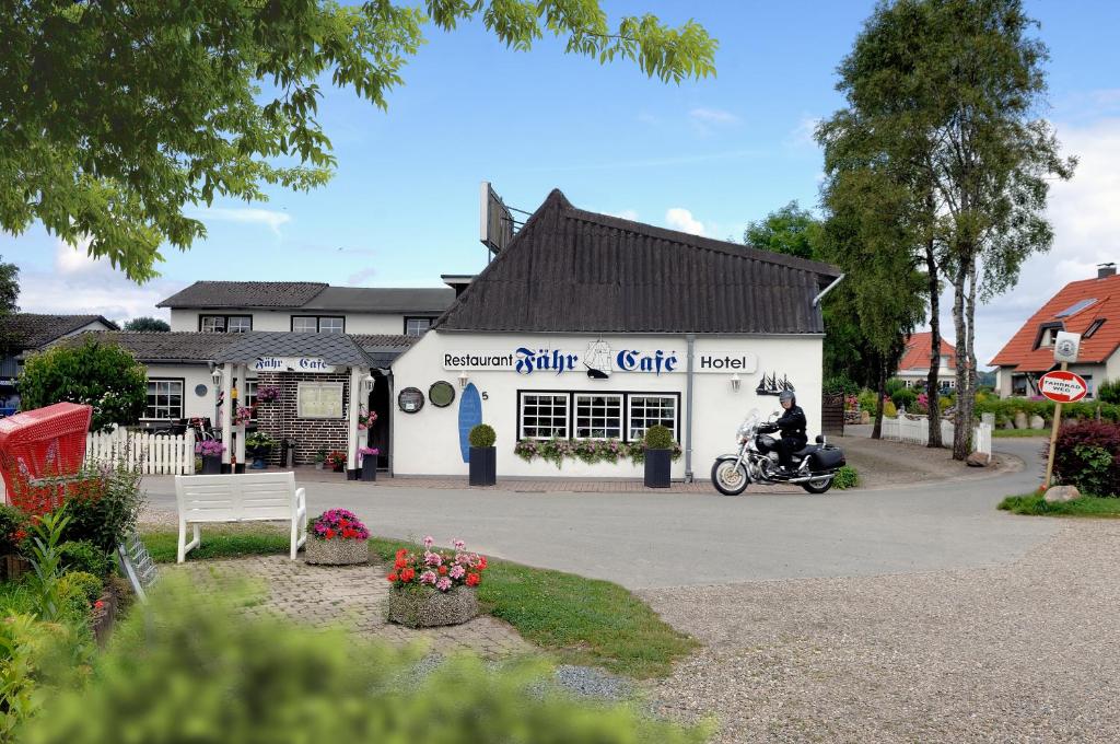 a man on a motorcycle in front of a building at Hotel-Restaurant Faehr-Cafe in Niesgrau